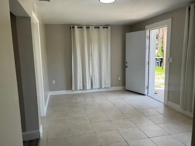 an empty room with window and a bathroom