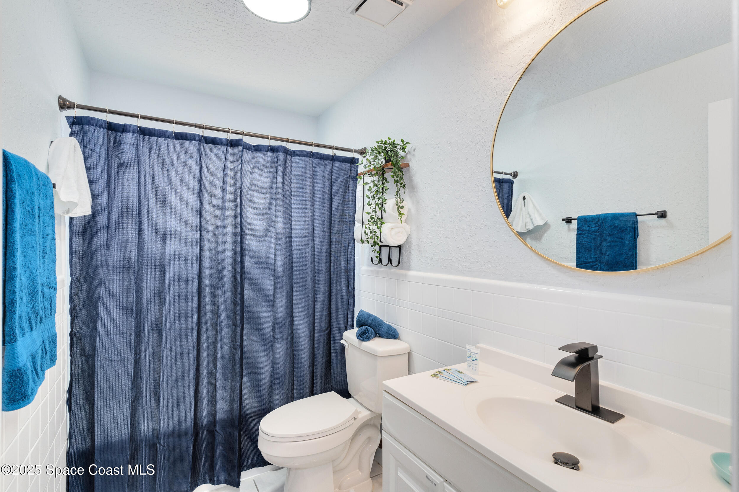 1029 Park Drive, Unit 32 Indian Harbour Beach, FL 32937 - Photo 16 of 35 a bathroom with a sink a toilet and shower curtain