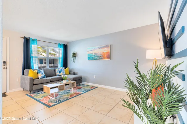 a living room with furniture and a potted plant