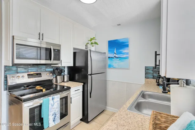 a kitchen with stainless steel appliances granite countertop a refrigerator stove and sink