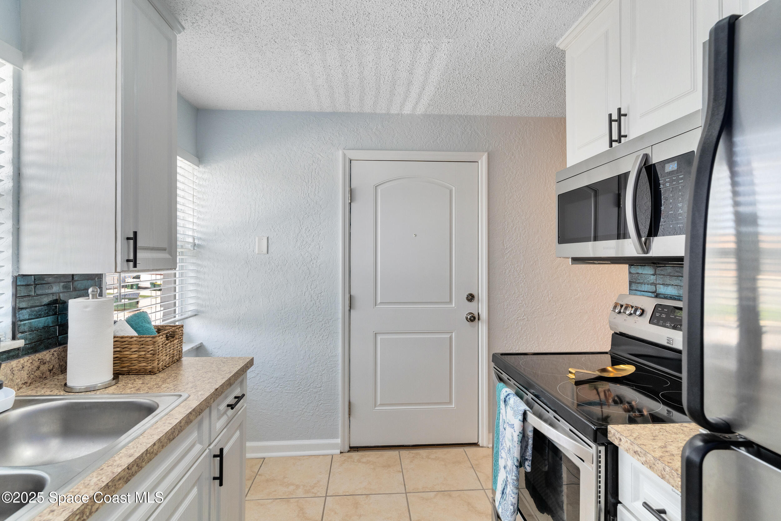 1029 Park Drive, Unit 32 Indian Harbour Beach, FL 32937 - Photo 8 of 35 a kitchen with stainless steel appliances granite countertop a sink stove and refrigerator