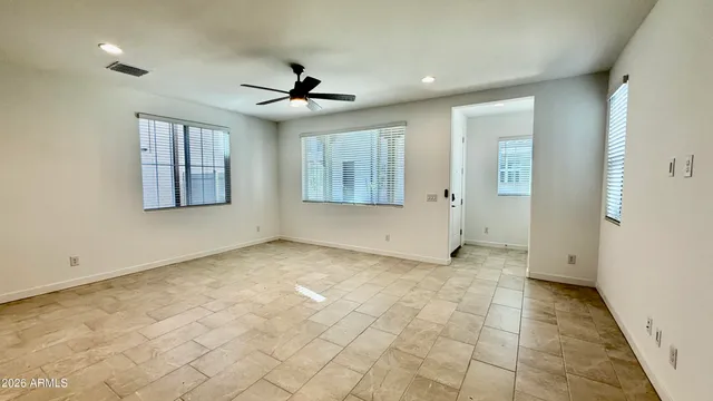 an empty room with windows and fan