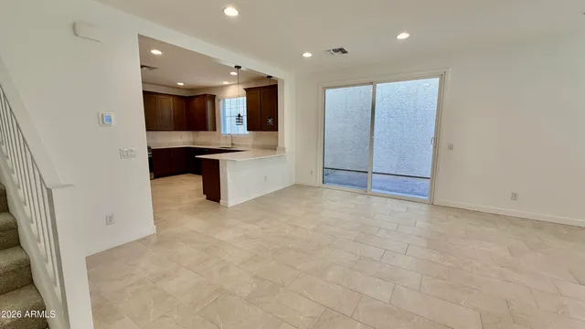 a view of a kitchen with kitchen island a sink wooden floor and a refrigerator
