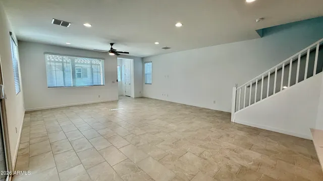 an empty room with windows and chandelier