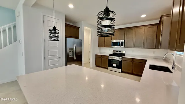 a kitchen with stainless steel appliances kitchen island granite countertop a stove and a refrigerator with wooden floor