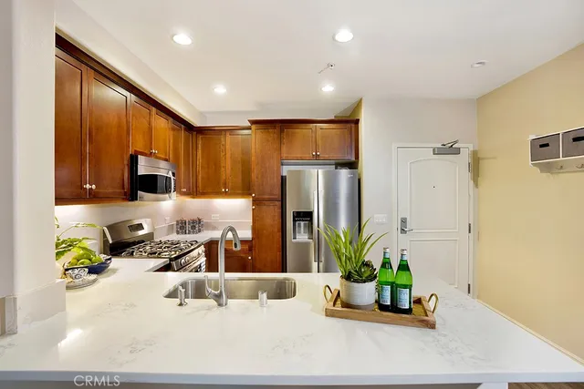 a kitchen with stainless steel appliances granite countertop sink a refrigerator and a counter top space