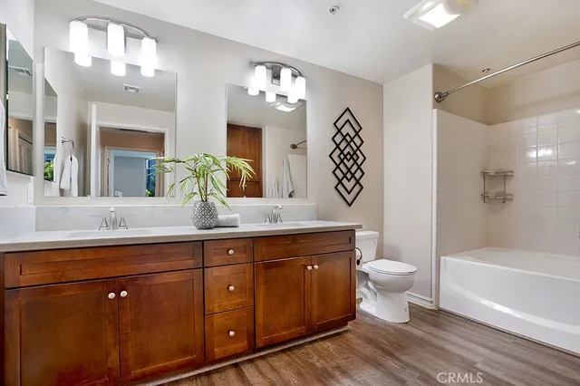 a spacious bathroom with a toilet a sink a mirror a bathtub and vanity