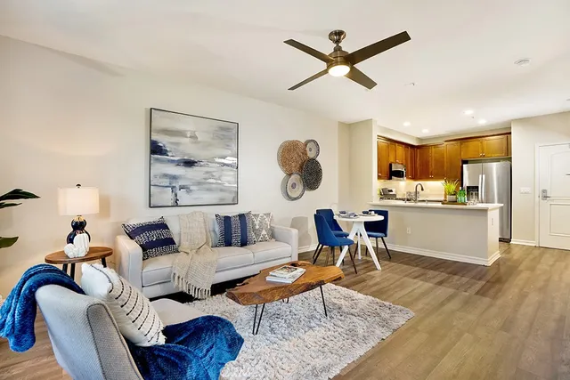 a living room with furniture kitchen view and a large window