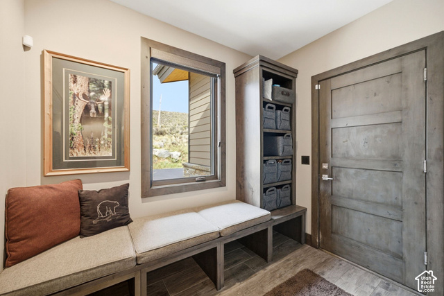 1130 Pace Road Park City, UT 84098 - Photo 52 of 73 Built-in bench seating with upholstered cushions, integrated storage cubbies, a wood-framed window, and a paneled wood-finish door with brushed nickel hardware