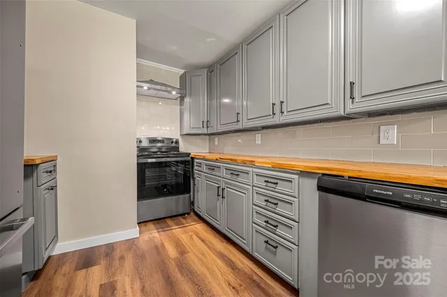 a kitchen with stainless steel appliances granite countertop a stove a sink and a refrigerator