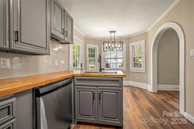 a kitchen with granite countertop a sink and a wooden floors