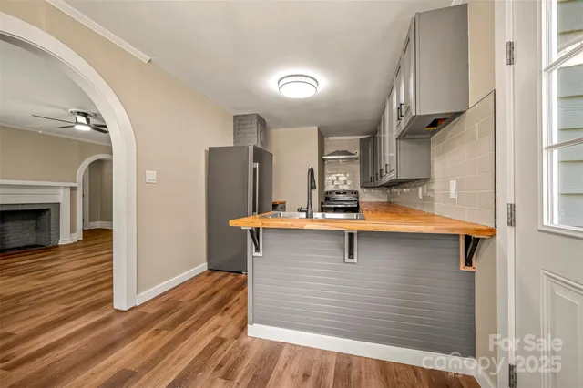 a view of kitchen with stainless steel appliances cabinets and wooden floor