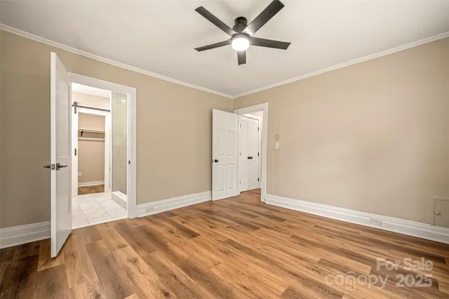 a view of a livingroom with wooden floor and a ceiling fan