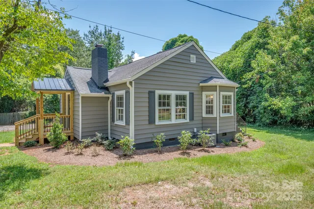 a view of a house with a yard and potted plants