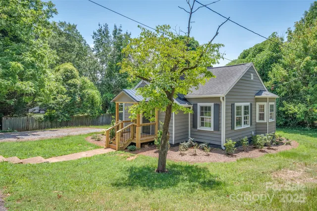 a view of a house with backyard and a tree