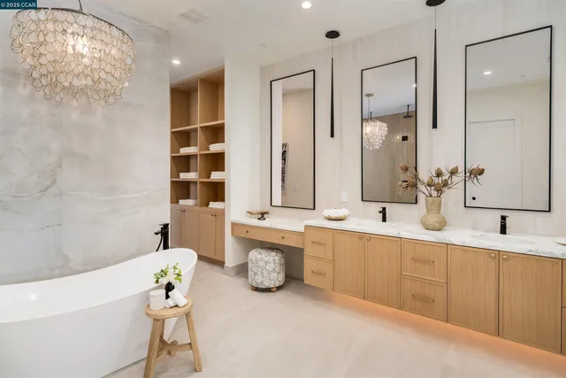 a bathroom with a granite countertop bathtub sink vanity mirror and toilet
