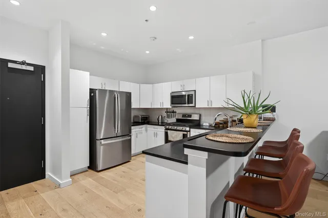 a kitchen with stainless steel appliances a refrigerator a stove top oven a sink and cabinets