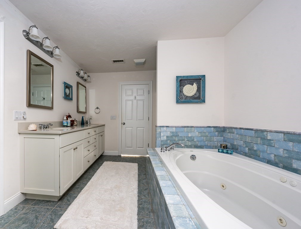 24 Miller Farm Road Mashpee, MA 02649 - Photo 19 of 28 a spacious bathroom with a tub sink a mirror and a bathtub