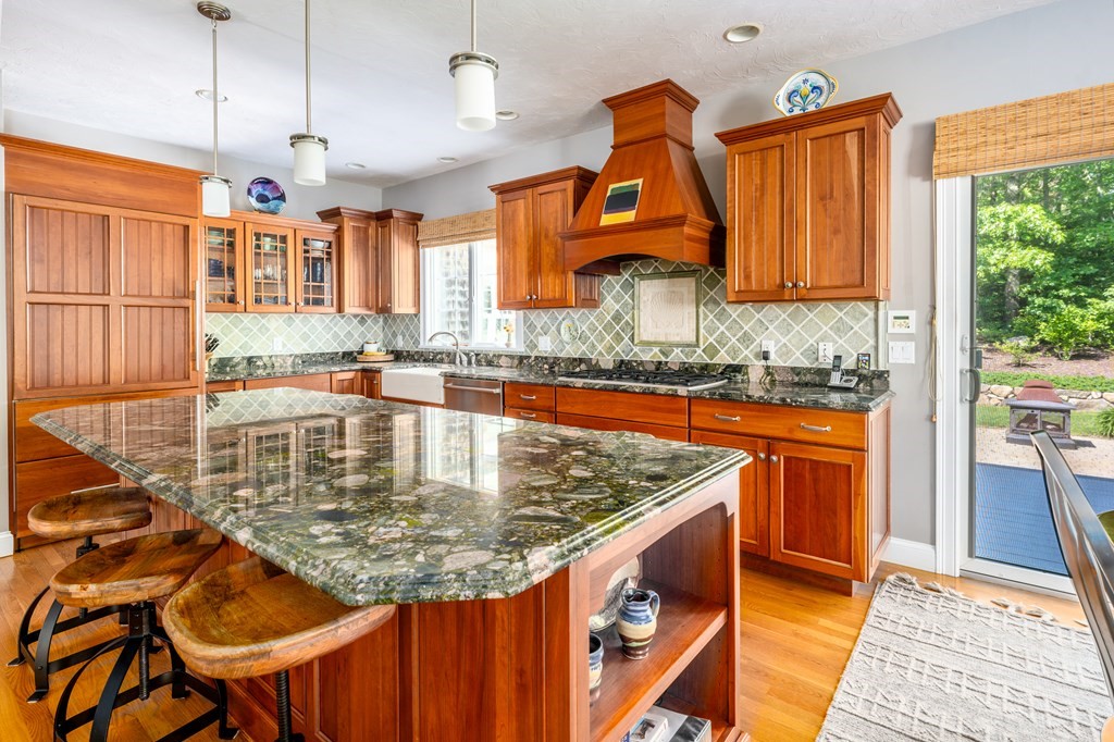 24 Miller Farm Road Mashpee, MA 02649 - Photo 7 of 28 a kitchen with stainless steel appliances granite countertop a sink dishwasher and cabinets with wooden floor