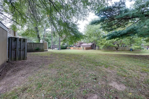a front view of a house with a yard and trees
