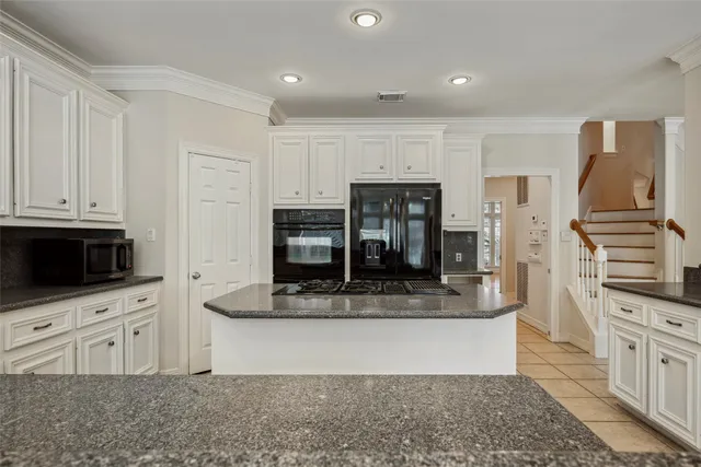 a kitchen with stainless steel appliances kitchen island granite countertop a stove a sink and a microwave