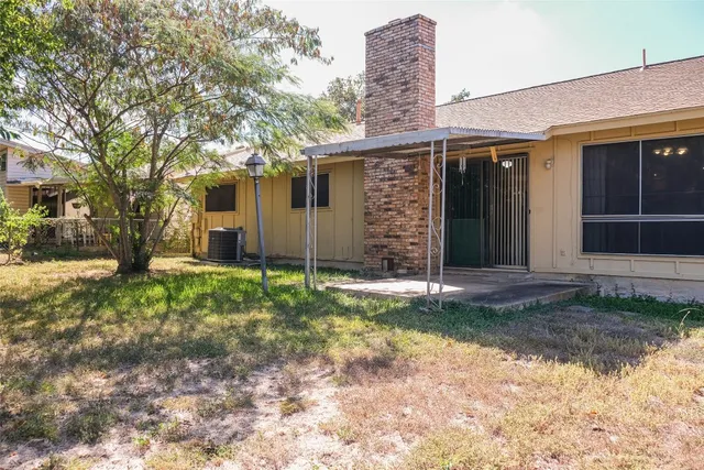 a view of a house with backyard and tree