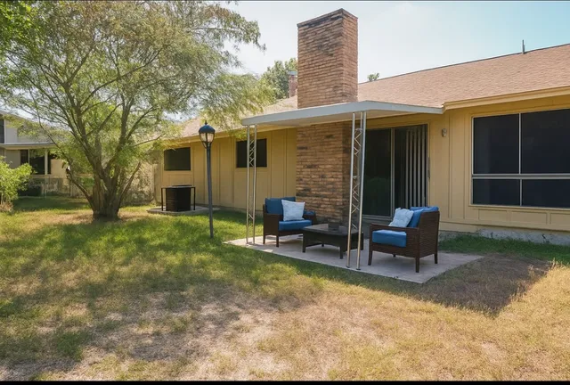 a view of a house with backyard and sitting area