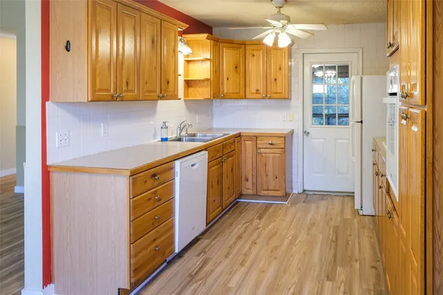 a kitchen with stainless steel appliances granite countertop a sink a stove cabinets and wooden floor