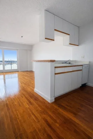 a kitchen with granite countertop a stove and a wooden floors