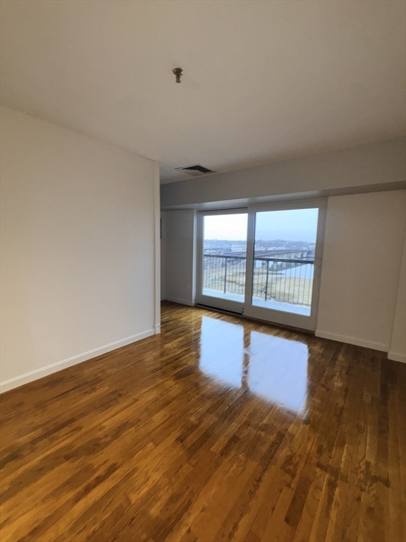133 Commander Shea Boulevard, Unit 709 Quincy, MA 02171 - Photo 9 of 16 wooden floor in an empty room with a window