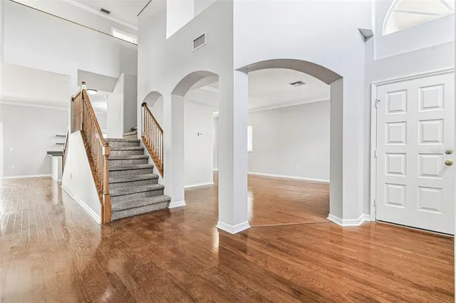 a view of empty room with wooden floor and window