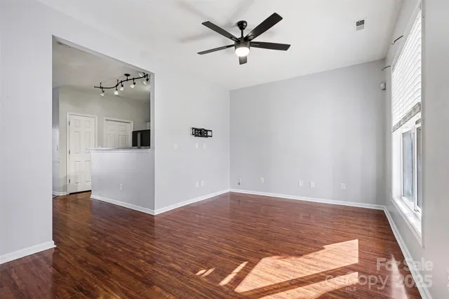 a view of a livingroom with wooden floor and a ceiling fan