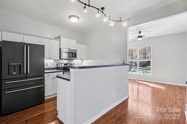 a kitchen with granite countertop a refrigerator and a stove top oven
