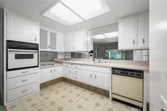 a kitchen with granite countertop white cabinets and white appliances