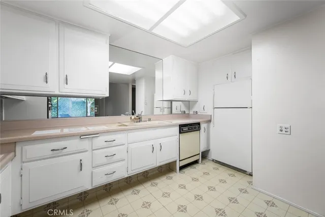 a kitchen with granite countertop white cabinets and white appliances