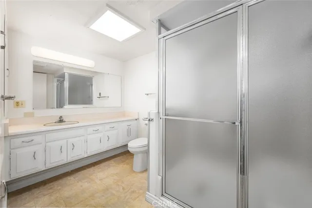 a bathroom with a double vanity sink toilet mirror and shower