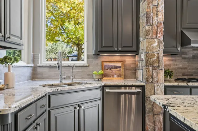a kitchen with stainless steel appliances granite countertop a sink stove and cabinets