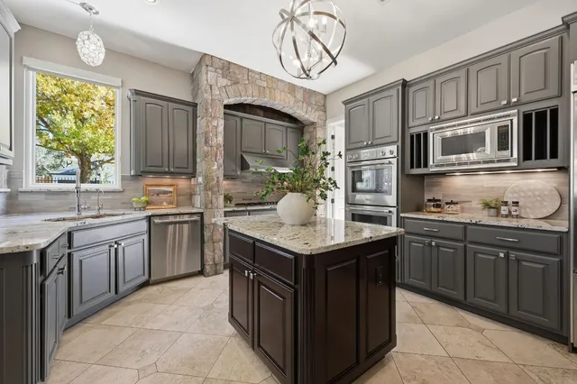 a kitchen with stainless steel appliances granite countertop a sink counter space cabinets and a large window