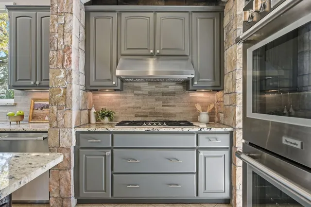 a kitchen with granite countertop a sink stove and cabinets