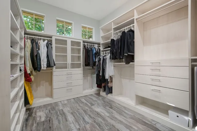 a view of walk in closet with clothes and shoes