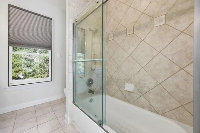 a bathroom with a bathtub and next to a shower