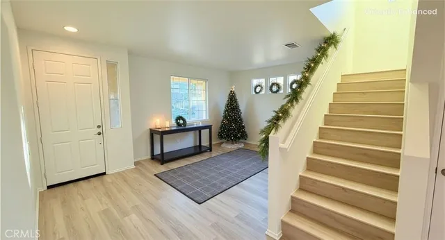 a living room with wooden floor and stairs