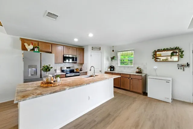 a kitchen with sink a counter top space and stainless steel appliances