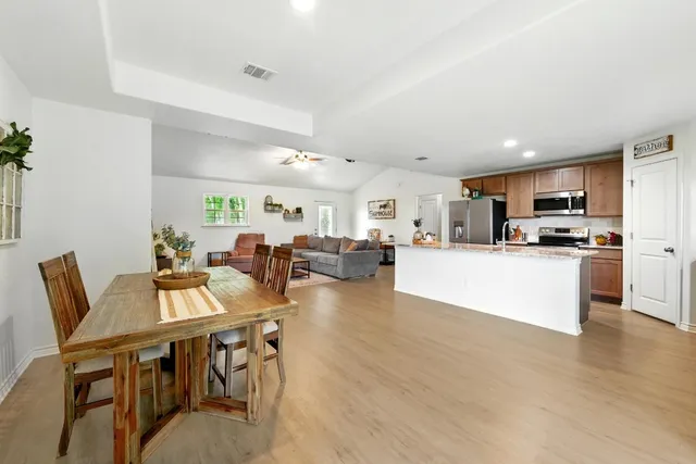 a living room with furniture dining table and kitchen view