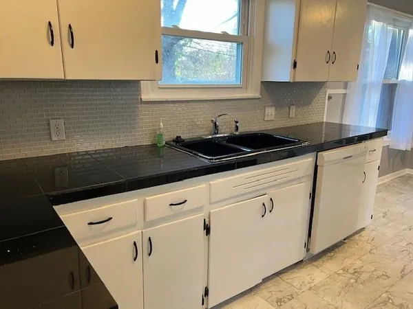 a kitchen with granite countertop white cabinets and white appliances