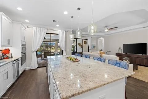 a kitchen with stainless steel appliances granite countertop a sink a stove and a refrigerator