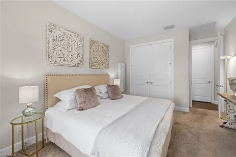 a bedroom with a bed a mirror and a large window