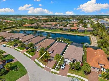 an aerial view of residential houses with outdoor space and ocean view