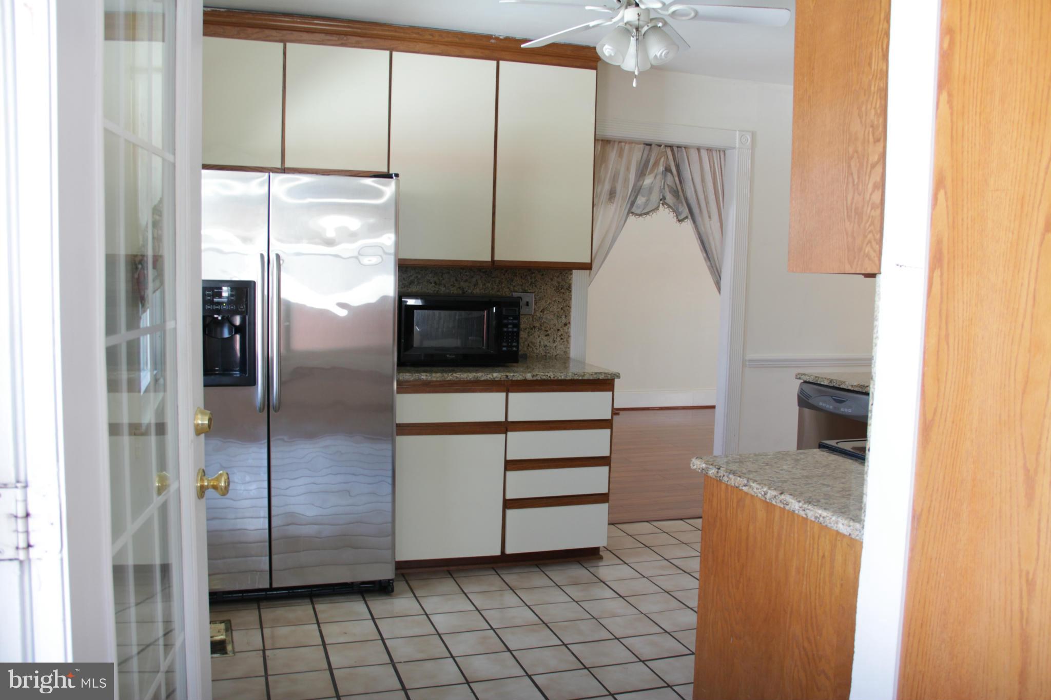 204 West Ash Road Sterling, VA 20164 - Photo 4 of 14 a kitchen with stainless steel appliances kitchen island granite countertop a refrigerator and a sink