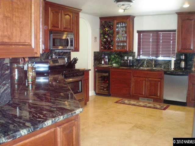 1622 Ray Court Fernley, NV 89408 - Photo 4 of 9 a kitchen with stainless steel appliances granite countertop a stove a sink and a microwave